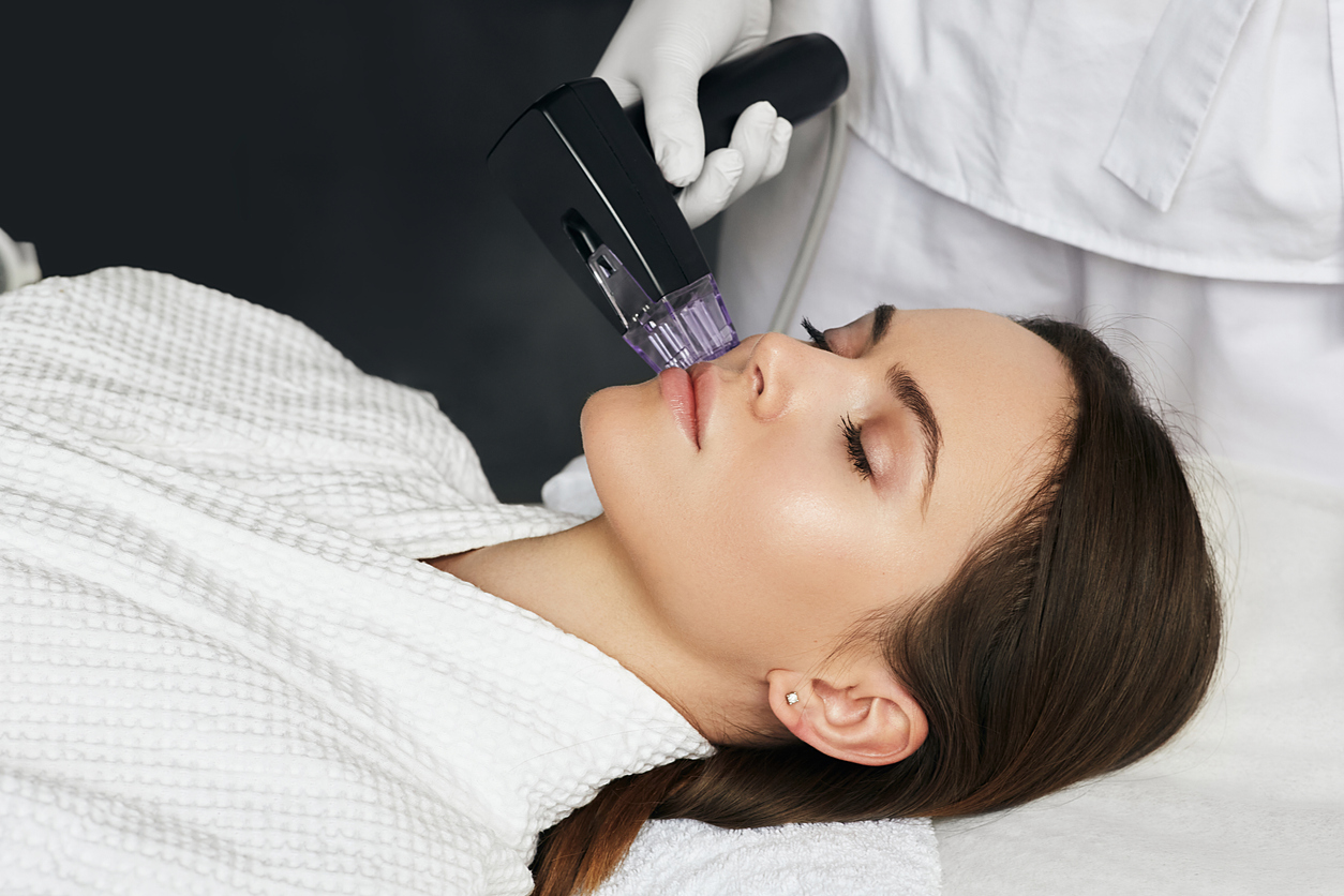 Brunette woman receiving radiofrequency lifting procedure for her face skin rejuvenation at aesthetic cosmetology clinic HALO AESTHETICS BAR - West Hollywood’s Best-Kept Beauty Secret